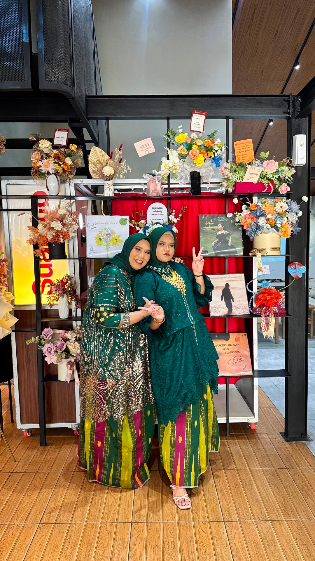 Baju bodo hijau dengan sarung tenun warna-warni
